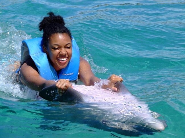 Young woman swimming with a dolphin at Dolphin Cove in Ocho Rios