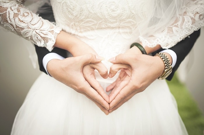 husband and wife forming a heart with their hands